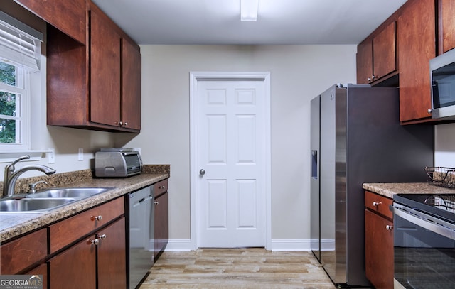 kitchen with light wood-type flooring, sink, and stainless steel appliances