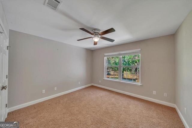 carpeted empty room with baseboards, visible vents, and ceiling fan