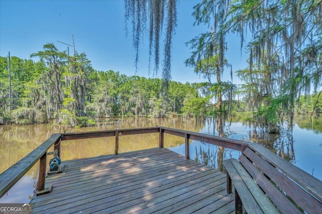 dock area with a deck with water view and a forest view