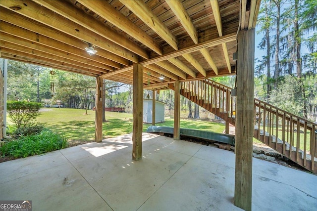 view of patio / terrace featuring an outdoor structure, stairway, and a storage shed