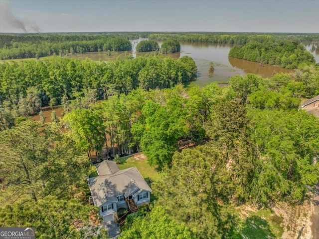 drone / aerial view featuring a wooded view and a water view