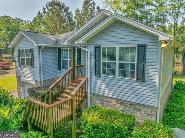 single story home with gravel driveway, a garage, cooling unit, and a front yard