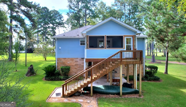 rear view of house with a yard and a sunroom