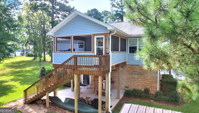 view of front of property featuring a sunroom, a front lawn, and a patio area