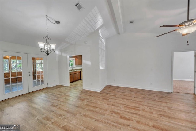 unfurnished living room featuring ceiling fan with notable chandelier, vaulted ceiling with beams, light wood-style floors, french doors, and visible vents