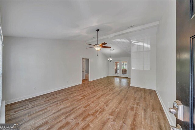 123 E Entreken Rd, Cobb, GA 31735 - unfurnished living room featuring ceiling fan with notable chandelier, vaulted ceiling with beams, light wood-style floors, french doors, and visible vents
