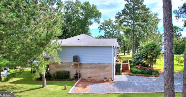 view of side of property with a lawn and central AC unit