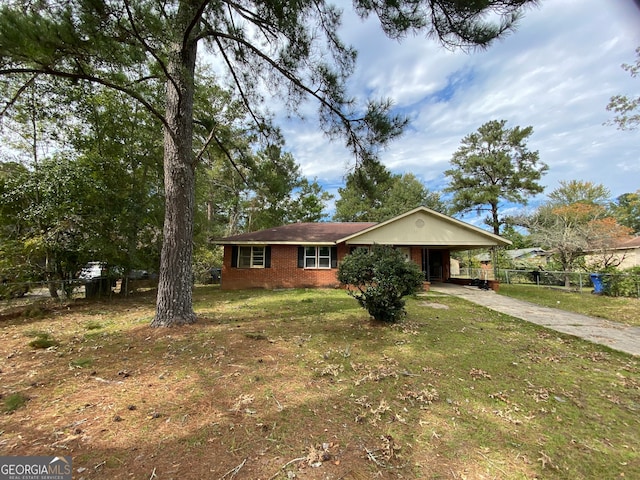 ranch-style home featuring a front lawn and a carport