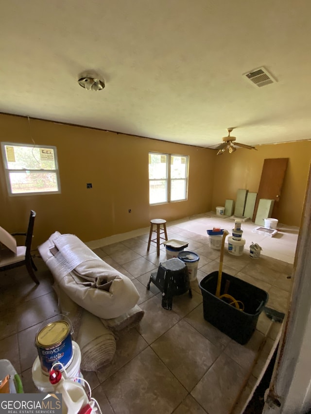 living room with ceiling fan and tile patterned flooring