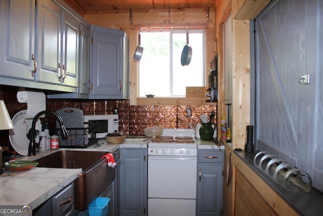 kitchen featuring sink, gray cabinets, white appliances, and tasteful backsplash