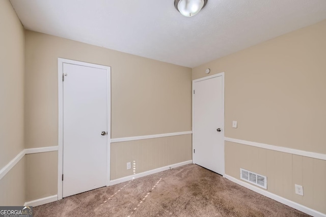 unfurnished room featuring carpet flooring and visible vents