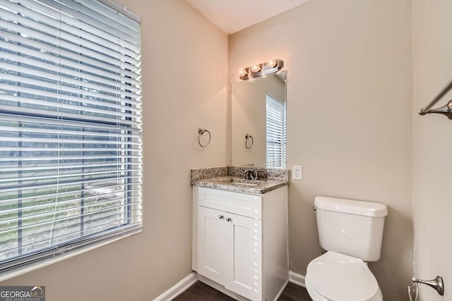 bathroom featuring vanity, baseboards, and toilet