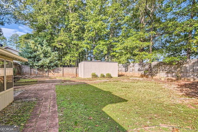view of yard with a fenced backyard, an outdoor structure, and a storage unit