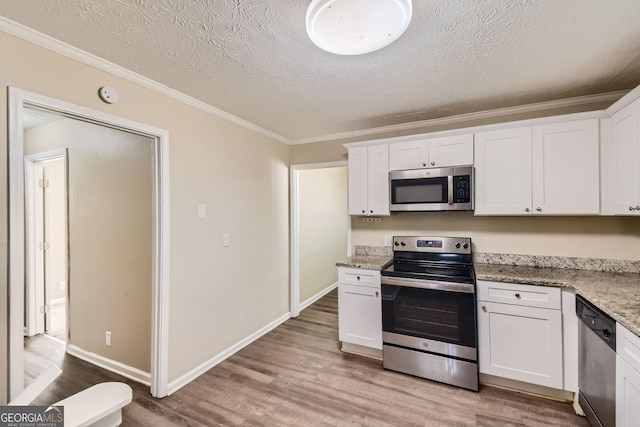 kitchen with light wood-style floors, ornamental molding, white cabinetry, and stainless steel appliances