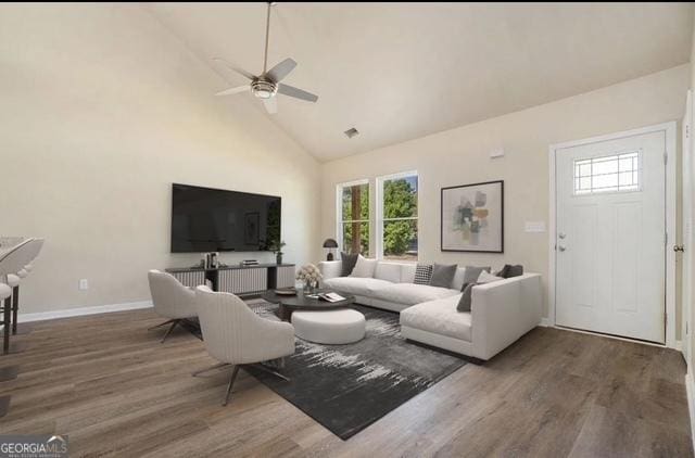 living room with high vaulted ceiling, ceiling fan, dark wood-type flooring, and a wealth of natural light