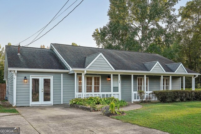 ranch-style house featuring a front lawn and covered porch