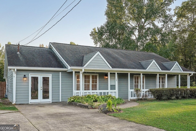 single story home with roof with shingles, a front yard, a porch, and french doors