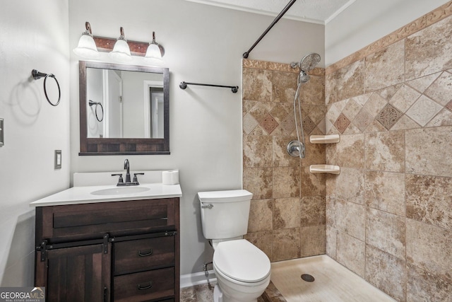 full bathroom with toilet, a tile shower, and vanity