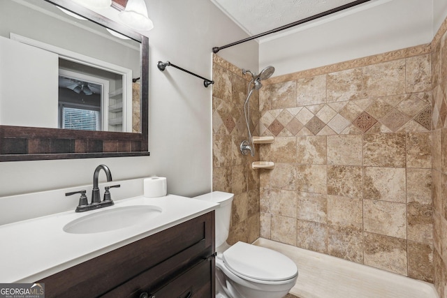 full bath featuring a tile shower, vanity, and toilet