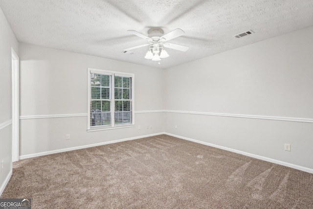 carpeted empty room with ceiling fan, visible vents, and baseboards