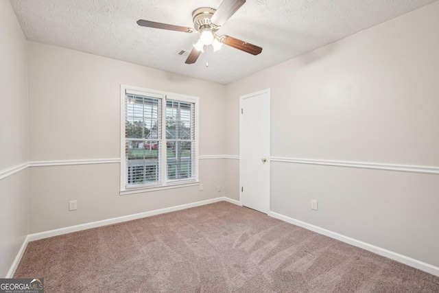 spare room featuring a ceiling fan, carpet, a textured ceiling, and baseboards