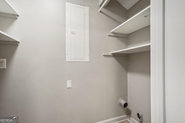 laundry area with laundry area, electric panel, and baseboards