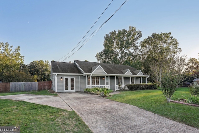 ranch-style home with french doors, a front lawn, a porch, and fence