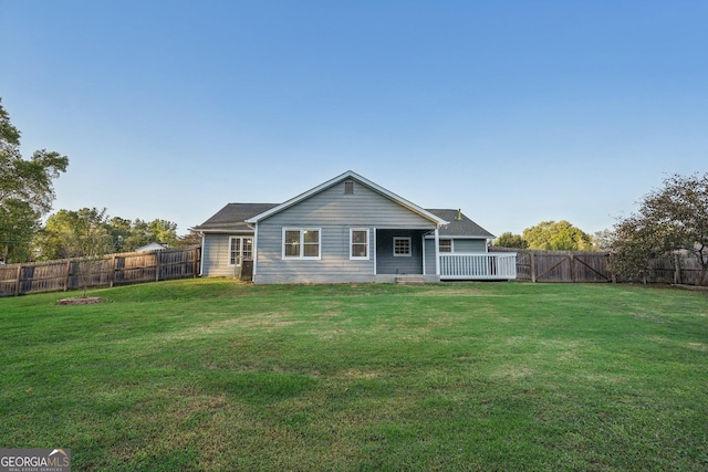 view of front of home with a front yard, a fenced backyard, and a wooden deck