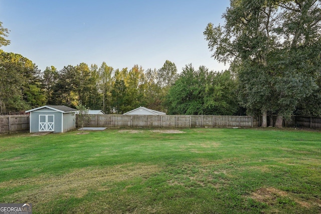 view of yard featuring a fenced backyard and a storage shed