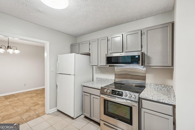 kitchen featuring decorative light fixtures, stainless steel appliances, gray cabinetry, an inviting chandelier, and a textured ceiling