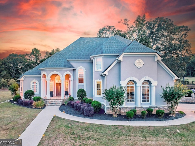 french country home featuring a yard