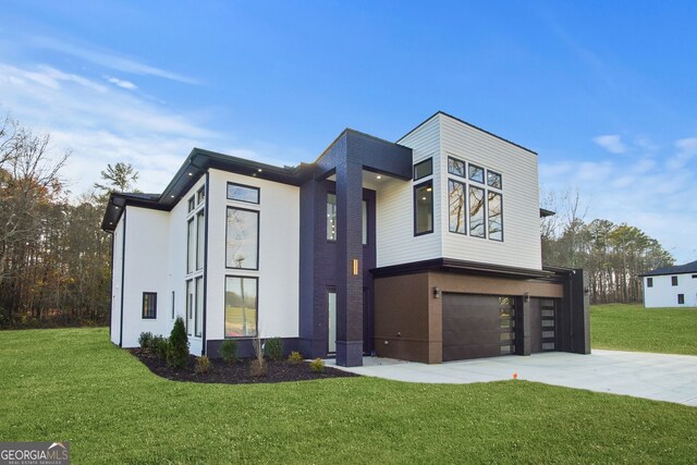 contemporary house featuring a garage and a front lawn