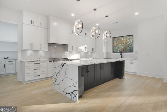 kitchen featuring decorative light fixtures, white cabinetry, and a large island