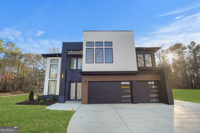 contemporary house featuring a front lawn and a garage