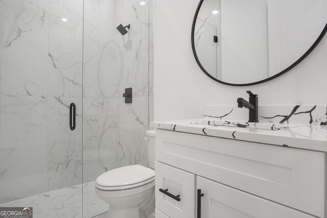 bathroom featuring a shower with door, toilet, and vanity