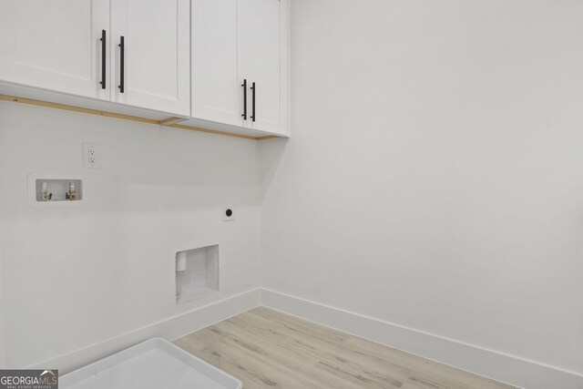 laundry room featuring light hardwood / wood-style floors, cabinets, hookup for a washing machine, and hookup for an electric dryer