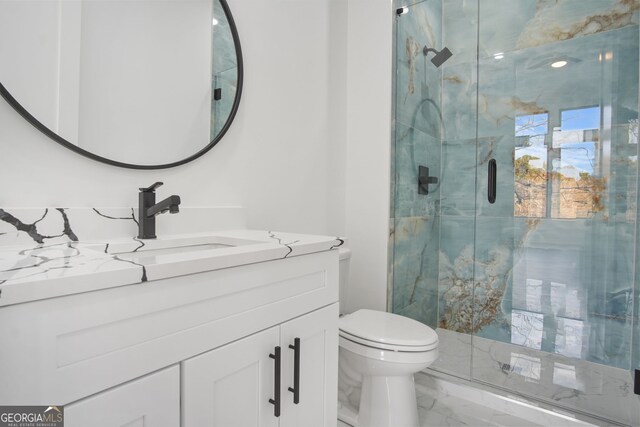 bathroom featuring toilet, vanity, and a shower with shower door