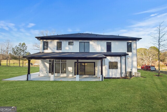 rear view of property with cooling unit, a yard, and a patio