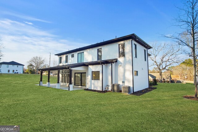 rear view of house featuring a lawn, central AC unit, and a patio area