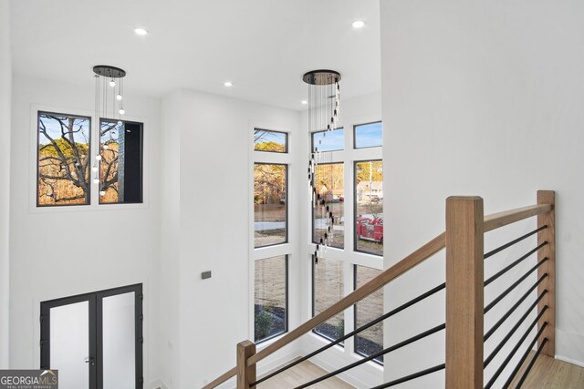 stairs with wood-type flooring, plenty of natural light, and french doors