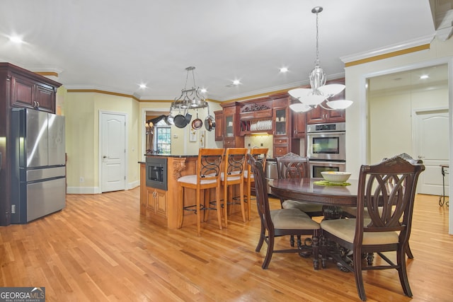 dining room with light hardwood / wood-style flooring, crown molding, and a chandelier