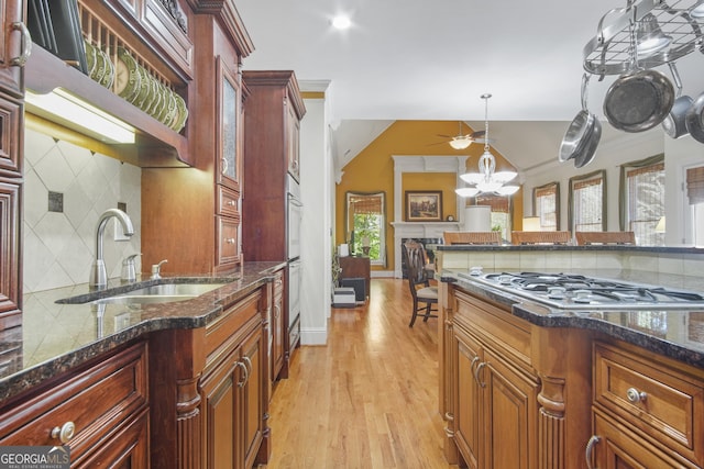 1565 Mountain Shadow Trl, Stone Mountain, GA 30087 - kitchen featuring dark stone countertops, a sink, gas cooktop, light wood finished floors, and backsplash