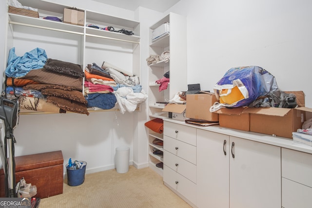 walk in closet featuring light colored carpet