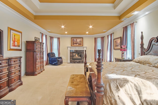 carpeted bedroom with a premium fireplace, crown molding, and a tray ceiling