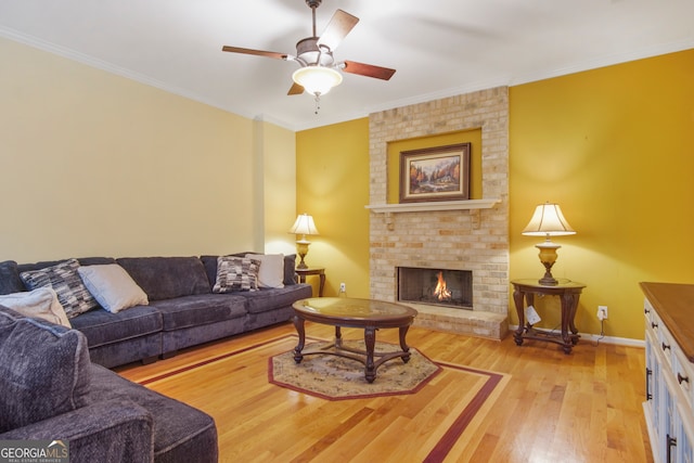 living room featuring ceiling fan, light hardwood / wood-style flooring, a fireplace, and ornamental molding