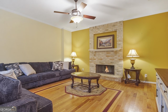 1565 Mountain Shadow Trl, Stone Mountain, GA 30087 - living room featuring a ceiling fan, crown molding, light wood-style flooring, baseboards, and a brick fireplace