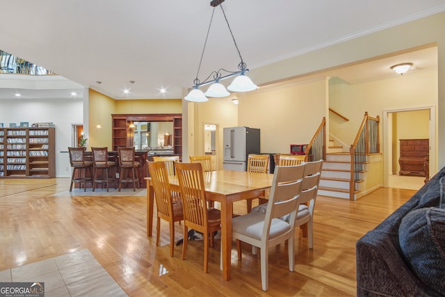 dining room with light hardwood / wood-style flooring and crown molding