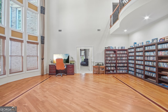 office with a high ceiling and wood-type flooring