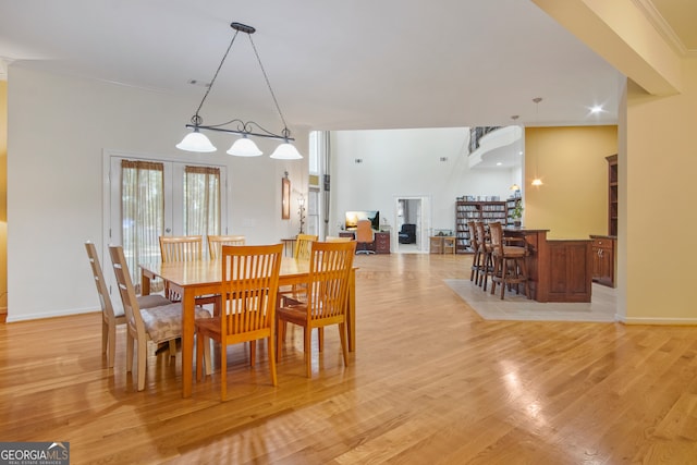 dining room with light wood-type flooring and crown molding