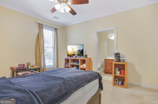 bedroom featuring ceiling fan, ornamental molding, light carpet, and ensuite bathroom